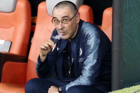 Chelsea head coach Maurizio Sarri smokes a cigaret on the bench after winning the Europa League Final soccer match between Chelsea and Arsenal at the Olympic stadium in Baku, Azerbaijan, Thursday, May 30, 2019. Chelsea won 4-1. (AP Photo/Darko Bandic)