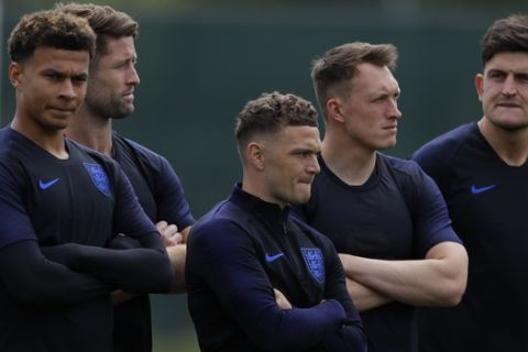 England's Dele Alli, left, with teammates Gary Cahill, Kieran Trippier, Phil Jones, and England's Harry Maguire wait for the start of a training session for the England team at the 2018 soccer World Cup, in the Spartak Zelenogorsk ground, Zelenogorsk near St. Petersburg, Russia, Wednesday, June 13, 2018. (AP Photo/Alastair Grant)