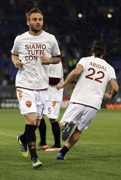 AS Roma player Daniele De Rossi (L) wears a t-shirt in support of Barcelona player Eric Abidal during the warm up before their Serie A match against Genoa at the Olympic stadium in Rome, March 19, 2012. The t-shirt reads " We are all with you".    REUTERS/Alessandro Bianchi   (ITALY - Tags: SPORT SOCCER)