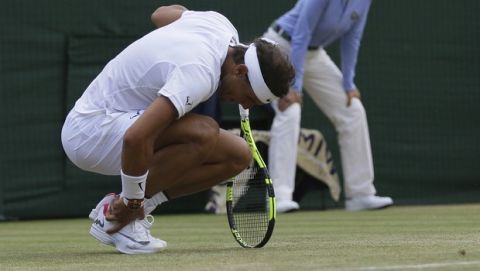 Spain's Rafael Nadal holds his ankle as he plays Luxembourg's Gilles Muller during their Men's Singles Match on day seven at the Wimbledon Tennis Championships in London Monday, July 10, 2017. (AP Photo/Tim Ireland)