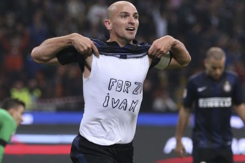 Inter Milan Argentine midfielder Esteban Cambiasso celebrates after scoring during the Serie A soccer match between Inter Milan and Hellas Verona at the San Siro stadium in Milan, Italy, Saturday, Oct. 26, 2013. The writing on the shirt "Forza Ivan" (Go Ivan) is a get well wish for his teammate Ivan Cordoba, recently hospitalized. (AP Photo/Antonio Calanni)
