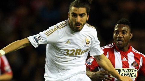 Sunderland's Stephane Sessegnon, right, vies for the bal with Swansea City's Chico Flores, left, during their English Premier League soccer match at the Stadium of Light, Sunderland, England, Tuesday, Jan. 29, 2013. (AP Photo/Scott Heppell)