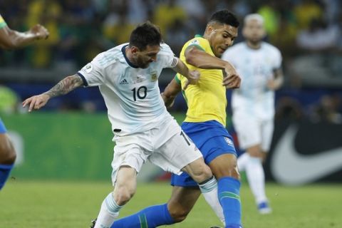 Argentina's Lionel Messi, left, vies for the ball with Brazil's Casemiro during a Copa America semifinal soccer match at Mineirao stadium in Belo Horizonte, Brazil, Tuesday, July 2, 2019. (AP Photo/Victor R. Caivano)