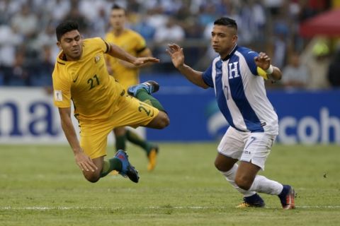 Australia's Massimo Luongo, left, is taken down by Honduras' Emilio Izaguirre during the first leg of a soccer World Cup qualifier play-off at the Olympic Stadium in San Pedro Sula, Honduras, Friday, Nov. 10, 2017. (AP Photo/Moises Castillo)