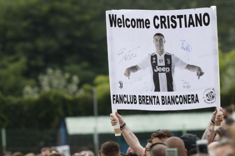 Supporters hold a banner welcoming Juventus' Cristiano Ronaldo as he arrives at Villar Perosa, northern Italy, Sunday, Aug.12, 2018, to take part in a friendly match between the Juventus A and B teams. (AP Photo/Antonio Calanni)