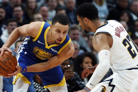 Golden State Warriors guard Stephen Curry, left, looks to pass the ball as Denver Nuggets guard Jamal Murray defends in the first half of an NBA basketball game, Tuesday, Jan. 15, 2019, in Denver. (AP Photo/David Zalubowski)