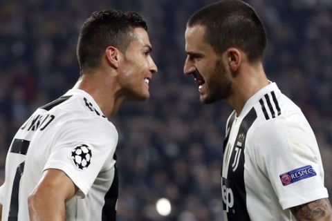 Juventus forward Cristiano Ronaldo celebrates with teammate Leonardo Bonucci, right, after scoring his side's opening goal during the Champions League group H soccer match between Juventus and Manchester United at the Allianz stadium in Turin, Italy, Wednesday, Nov. 7, 2018. (AP Photo/Antonio Calanni)