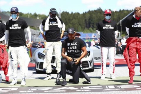 Mercedes driver Lewis Hamilton of Britain, centre, takes a knee n support of the Black Lives Matter movement before the Austrian Formula One Grand Prix race at the Red Bull Ring racetrack in Spielberg, Austria, Sunday, July 5, 2020. (Dan Istitene/Pool via AP)