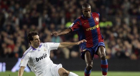 FC Barcelona's Abidal, right, vies for the ball with Real Madrid's Dutch player Ruud Van Nistelrooy, left, during their Spanish league soccer match at the Camp Nou stadium in Barcelona, Spain, Sunday, Dec. 23, 2007. (AP Photo/Manu Fernandez)