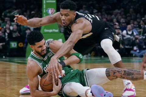 Boston Celtics forward Jayson Tatum, left, grabs a loose ball next to Milwaukee Bucks forward Giannis Antetokounmpo during the second half of Game 2 of an Eastern Conference semifinal in the NBA basketball playoffs Tuesday, May 3, 2022, in Boston. (AP Photo/Charles Krupa)