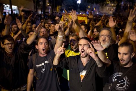 Demonstrators protest outside the main offices of the left wing party CUP in Barcelona, Spain, Wednesday, Sept. 20, 2017. Protesters rejoiced in the evening around the headquarters of the anti-establishment CUP political party when National Police officers left after having waited for hours for a permission from a judge to search the premises for referendum-related propaganda that never arrived. (AP Photo/Emilio Morenatti)