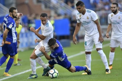 Real Madrid's Lucas Vazquez, second left, fights for the ball with Alaves's Medran during the Spanish La Liga soccer match between Real Madrid and Alaves, at Mendizorra stadium, in Vitoria, northern Spain, Saturday, Sept. 23, 2017. Real Madrid won the match 2-1. (AP Photo/Alvaro Barrientos)