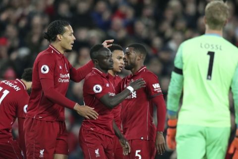 Liverpool teammates celebrate after scoring their side's second goal during the English Premier League soccer match between Liverpool and Huddersfield Town at Anfield Stadium, in Liverpool, England, Friday, April 26, 2019.(AP Photo/Jon Super)