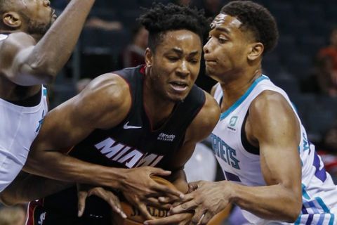 Miami Heat forward KZ Okpala, center, fights through a double-team by Charlotte Hornets forwards Michael Kidd-Gilchrist, left, and PJ Washington during the second half of an NBA preseason basketball game in Charlotte, N.C., Wednesday, Oct. 9, 2019. (AP Photo/Nell Redmond)
