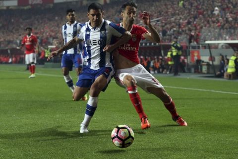 Porto's Maxi Pereira, left, vies for the ball with Benfica's Jonas during a Portuguese league soccer match between Benfica and FC Porto at the Luz stadium in Lisbon, Saturday, April 1, 2017. (AP Photo/Armando Franca)