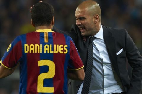 Barcelona's Pep Guardiola reacts as he talks with Dani Alves during their Spanish La liga soccer match against Valencia at the Camp Nou stadium in Barcelona, Spain, Saturday, Oct. 16, 2010. (AP Photo/Siu Wu)