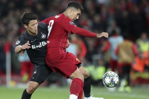 Liverpool's Roberto Firmino, right, duels for the ball with Salzburg's Hwang Hee-chan during the Champions League group E soccer match between Liverpool and Red Bull Salzburg at Anfield stadium in Liverpool, England, Wednesday, Oct. 2, 2019. (AP Photo/Jon Super)