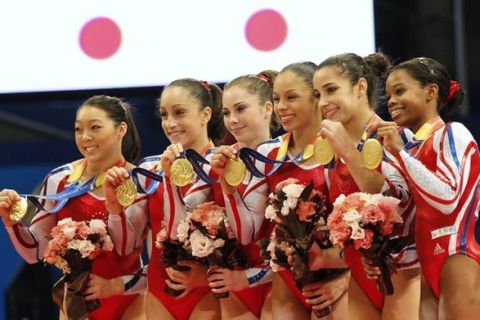 U.S. team members show their gold medals on the podium during the medal ceremony after winning the women's team final at the Artistic Gymnastics World Championships in Tokyo October 11, 2011.   REUTERS/Kim Kyung-Hoon (JAPAN - Tags: SPORT GYMNASTICS)