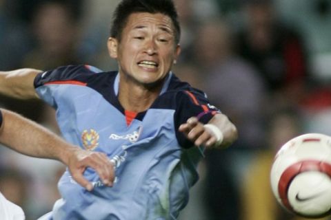 Japanese soccer star Kazuyoshi Miura, right, playing for Sydney FC, battles with Melbourne Victory FC's  defender Kevin Muscat in Sydney, Australia, Saturday, Dec. 3, 2005 .  Miura is a guest player with the Sydney Football Club and will play four matches in Australia's A-League competition before returning to Japan. Sydney FC won the match 2-0. (AP Photo/Rob Griffith)