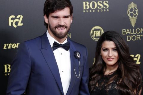 Liverpool's goalkeeper Alisson Becker poses with his wife Natalia Loewe during the Golden Ball award ceremony at the Grand Palais in Paris, Monday, Dec. 2, 2019. Awarded every year by France Football magazine since Stanley Matthews won it in 1956, the Ballon d'Or, Golden Ball for the best player of the year will be given to both a woman and a man. (AP Photo/Francois Mori)