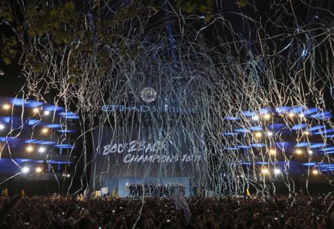 Streamers fill the night sky as the Manchester City team celebrate with their supporters at the Etihad Stadium in Manchester, England, Sunday May 12, 2019 the day they won the English Premier League title. Manchester City retained the Premier League trophy after coming from behind to beat Brighton 4-1 and see off Liverpool's relentless challenge on the final day of the season on Sunday. (AP Photo/Jon Super)