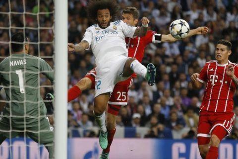 Real Madrid's Marcelo, center left, and Bayern's Thomas Mueller challenge for the ball watched by Real Madrid's goalkeeper Keylor Navas, left, and Bayern's James during the Champions League semifinal second leg soccer match between Real Madrid and FC Bayern Munich at the Santiago Bernabeu stadium in Madrid, Spain, Tuesday, May 1, 2018. (AP Photo/Francisco Seco)