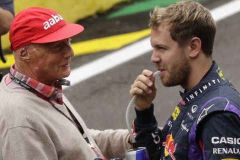 Red Bull driver Sebastian Vettel of Germany, right, talks with former driver Niki Lauda of Austria before the group photo ahead of the Brazilian Formula One Grand Prix at the Interlagos race track in Sao Paulo, Brazil, Sunday, Nov. 24, 2013. Vettel, who had already wrapped up a fourth straight F1 title,  won Formula One's season-ending Brazilian Grand Prix on Sunday, matching Michael Schumacher's record of 13 victories in a year and equaling the nine consecutive wins of Alberto Ascari. (AP Photo/Silvia Izquierdo)