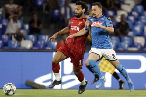 Liverpool's Mohamed Salah, left, and Napoli's Mario Rui fight for the ball during the Champions League Group E soccer match between Napoli and Liverpool, at the San Paolo stadium in Naples, Italy, Tuesday, Sept. 17, 2019. (AP Photo/Gregorio Borgia)