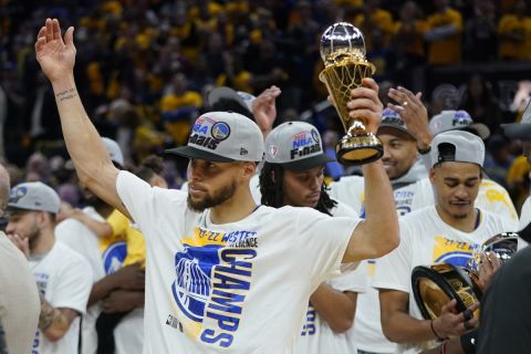 Golden State Warriors' Stephen Curry celebrates with the conference finals MVP trophy after defeating the Dallas Mavericks in Game 5 of the NBA basketball playoffs Western Conference finals in San Francisco, Thursday, May 26, 2022. (AP Photo/Jeff Chiu)