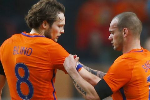 Netherlands' Wesley Sneijder, right, gives his captain's armband to Netherlands' Daley Blind when leaving the pitch after sustaining an injury during a international friendly soccer match between The Netherlands and France at the ArenA stadium in Amsterdam, Netherlands, Friday, March 25, 2016. (AP Photo/Peter Dejong)