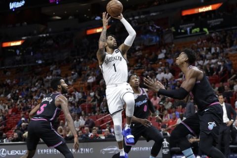 Brooklyn Nets' D'Angelo Russell (1) shoots over Miami Heat's Derrick Jones Jr. (5), Josh Richardson (0) and Hassan Whiteside, right, during the first half of an NBA basketball game, Tuesday, Nov. 20, 2018, in Miami. (AP Photo/Lynne Sladky)