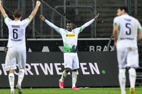 Moenchengladbach's Breel Embolo, center, celebrates after their second goal during the German Bundesliga soccer match between Borussia Moenchengladbach and 1.FC Cologne in Moenchengladbach, Germany, Wednesday, March 11, 2020. It is the first Bundesliga match played behind closed doors without spectators due to the coronavirus outbreak. (AP Photo/Martin Meissner)