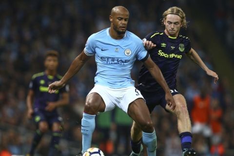 Manchester City's Vincent Kompany, left, and Everton's Tom Davies battle for the ball during the English Premier League soccer match between Manchester City and Everton at the Etihad Stadium in Manchester, England, Monday, Aug. 21, 2017. (AP Photo/Dave Thompson)
