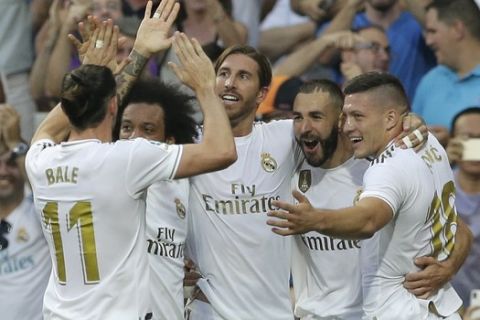 Real Madrid's Karim Benzema, second right, celebrates with his teammates after scoring his side's first goal during the Spanish La Liga soccer match between Real Madrid and Valladolid at the Santiago Bernabeu stadium in Madrid, Spain, Saturday, Aug. 24, 2019. (AP Photo/Paul White)