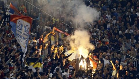 Serbian soccer fans fans burn NATO flag during the Euro 2016 Group I qualifying match between Serbia and Albania, at the Partizan stadium in Belgrade, Serbia, Tuesday, Oct. 14, 2014.(AP Photo/Darko Vojinovic)