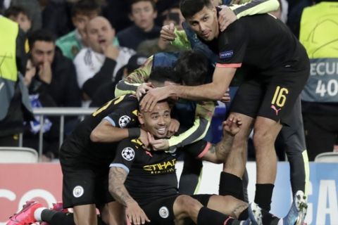 Manchester City's Gabriel Jesus celebrates with teammates after scoring his side's first goal during the round of 16 first leg Champions League soccer match between Real Madrid and Manchester City at the Santiago Bernabeu stadium in Madrid, Spain, Wednesday, Feb. 26, 2020. (AP Photo/Bernat Armangue)