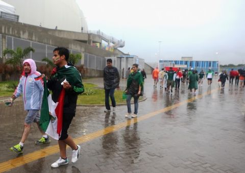 NATAL, BRAZIL - JUNE 13:  Fans brave the rain before the 2014 FIFA World Cup Brazil Group A match between Mexico and Cameroon at Estadio das Dunas on June 13, 2014 in Natal, Brazil.  (Photo by Miguel Tovar/Getty Images)
