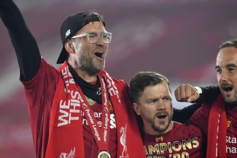 Liverpool's manager Jurgen Klopp, left, celebrates following the English Premier League soccer match between Liverpool and Chelsea at Anfield Stadium in Liverpool, England, Wednesday, July 22, 2020. Liverpool are champions of the EPL for the season 2019-2020. The trophy is presented at the teams last home game of the season. Liverpool won the match against Chelsea 5-3. (Paul Ellis, Pool via AP)