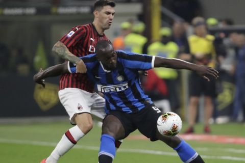 Inter Milan's Romelu Lukaku, front, fights for the ball with AC Milan's Alessio Romagnoli during a Serie A soccer match between AC Milan and Inter Milan, at the San Siro stadium in Milan, Italy, Saturday, Sept.21, 2019. (AP Photo/Luca Bruno)