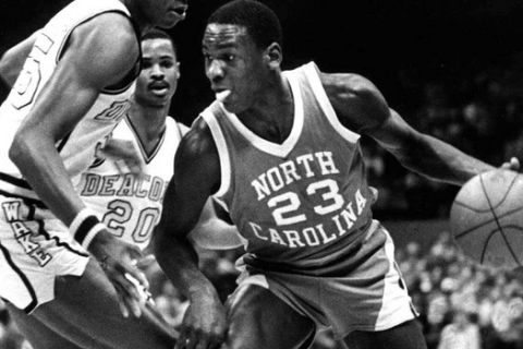 FILE - In this Feb. 17, 1982, file photo, North Carolina's Michael Jordan (23) drives around the defense of Wake Forest's Anthony Teachey, left, and Danny Young (20) at the Greensboro Coliseum in Greensboro, N.C. The ACC's claim to the all-time poll throne starts with North Carolina and Duke. (AP Photo/Bob Jordan, File)