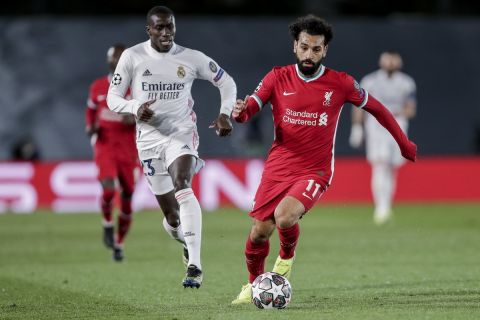 Liverpool's Mohamed Salah, right, controls the ball next to Real Madrid's Ferland Mendy, left, during the Champions League quarterfinal first leg, soccer match between Real Madrid and Liverpool at the Alfredo di Stefano stadium in Madrid, Spain, Tuesday, April 6, 2021. (AP Photo/Manu Fernandez)