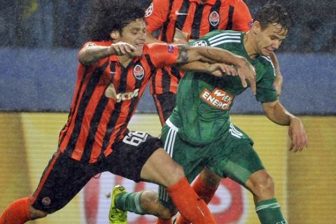 Rapid's Louis Schaub, right, and Shakhtar's Marcio Azevedo challenge for the ball during their Champions League play-off first leg soccer match between SK Rapid Wien and FC Shakhtar Donetsk in Vienna, Austria, Wednesday, Aug. 19, 2015. (AP Photo/Hans Punz)