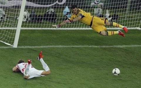 Spain goalkeeper Iker Casillas, right, makes a save as Croatia's Ivan Rakitic, left, lies on the ground during the Euro 2012 soccer championship Group C match between Croatia and Spain in Gdansk, Poland, Monday, June 18, 2012. (AP Photo/Gero Breloer) 