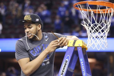 Kentucky's Karl-Anthony Towns holds part of the net in his teeth after Kentucky's 68-66 win over Notre Dame in a college basketball game in the NCAA men's tournament regional finals, Saturday, March 28, 2015, in Cleveland. (AP Photo/Tony Dejak)