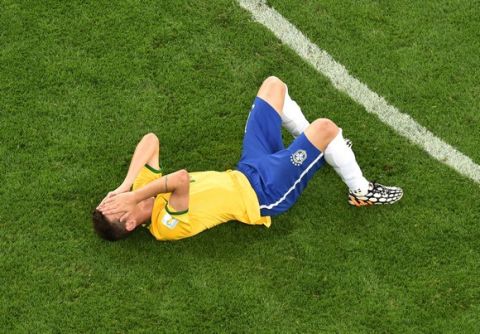 BELO HORIZONTE, BRAZIL - JULY 08: A dejected Oscar of Brazil lies on the pitch after being defeated by Germany 7-1 during the 2014 FIFA World Cup Brazil Semi Final match between Brazil and Germany at Estadio Mineirao on July 8, 2014 in Belo Horizonte, Brazil.  (Photo by Francois Xavier Marit - Pool/Getty Images)