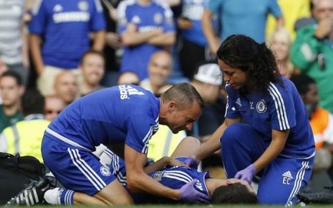 Chelsea doctor (R) Eva Carneiro and head physio Jon Fearn (L) treat Chelsea's Belgian midfielder Eden Hazard late on during the English Premier League football match between Chelsea and Swansea City  at Stamford Bridge in London on August 8, 2015. Chelsea have sidelined team doctor Eva Carneiro from match-day duties after she fell foul of manager Jose Mourinho, according to British media reports on August 11, 2015. Mourinho criticised Carneiro after she ran on the pitch to treat Eden Hazard in stoppage time of Chelsea's 2-2 draw at home to Swansea City on August 8, saying she did not "understand the game". AFP PHOTO / IAN KINGTON  RESTRICTED TO EDITORIAL USE. No use with unauthorized audio, video, data, fixture lists, club/league logos or 'live' services. Online in-match use limited to 75 images, no video emulation. No use in betting, games or single club/league/player publications.IAN KINGTON/AFP/Getty Images