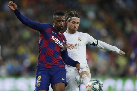 Barcelona's Nelson Semedo and Real Madrid's Sergio Ramos, right, compete for the ball during the Spanish La Liga soccer match between Real Madrid and Barcelona at the Santiago Bernabeu stadium in Madrid, Spain, Sunday, March 1, 2020. (AP Photo/Manu Fernandez)