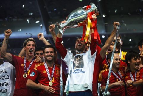 KIEV, UKRAINE - JULY 01:  Sergio Ramos (C) of Spain lifts the trophy next to team-mates Fernando Torres, Juan Mata, Andres Iniesta and David Silva as they celebrates following victory in the UEFA EURO 2012 final match between Spain and Italy at the Olympic Stadium on July 1, 2012 in Kiev, Ukraine.  (Photo by Laurence Griffiths/Getty Images)