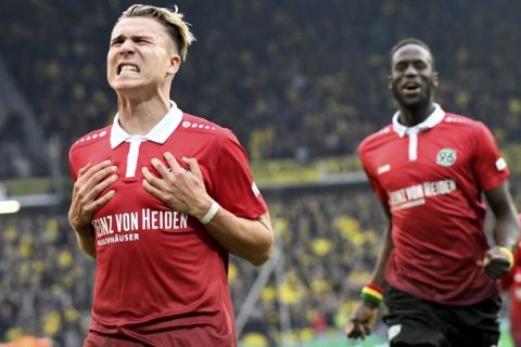 Hannover's Felix Klaus, left, celebrates during the Bundesliga soccer match between Hannover 96 and Borussia Dortmund in Hannover, Germany, Saturday, Oct. 28, 2017.  (Peter Steffen/dpa via AP)