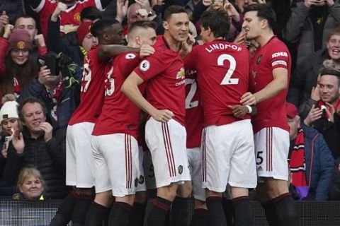 Manchester United's team players celebrate after Anthony Martial scored the opening goal during the English Premier League soccer match between Manchester United and Manchester City at Old Trafford in Manchester, England, Sunday, March 8, 2020. (AP Photo/Dave Thompson)
